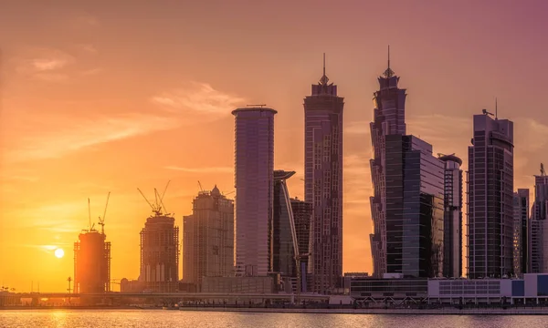ドバイ 紫の日の出 アラブ首長国連邦の中に高層ビルの水の反射とビジネス ベイのパノラマ ビューの景観 — ストック写真