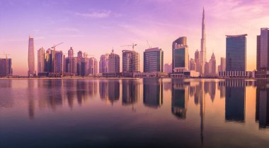 Cityscape Dubai ve gökdelenler su yansıma mor gündoğumu, BAE sırasında iş Körfezi'nin panoramik