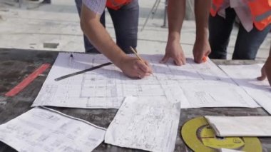 Mimari plan için pusula ve planlarla çalışan iki mimar, bir inşaat projesi konsepti çizen mühendis.