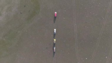 Üst Manzara. İHA saldırısı. Ukrayna 'nın taşrasında toprak yolda dört 4WD araba sürüyor..