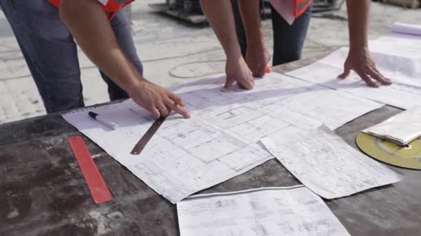 集中的专业男性工程师绘制最终施工计划的支出图，作为建筑商的指南，详细说明管道供热、电力通风和结构系统 — 图库视频影像