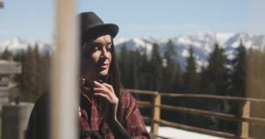 Yavaş çekim, pencerenin yeniden çekilmesi, güzel esmer bir kadının güneş gözlüğünü çıkardığı ve dikkatlice yansımasına baktığı görüntüler..