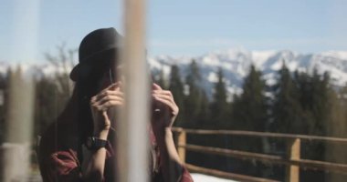 Yakın plan, güzel esmer beyaz bir kadının yansımasına dikkatle bakıp güneş gözlüğünü takıp yavaşça uzaklaştığı görüntüler..