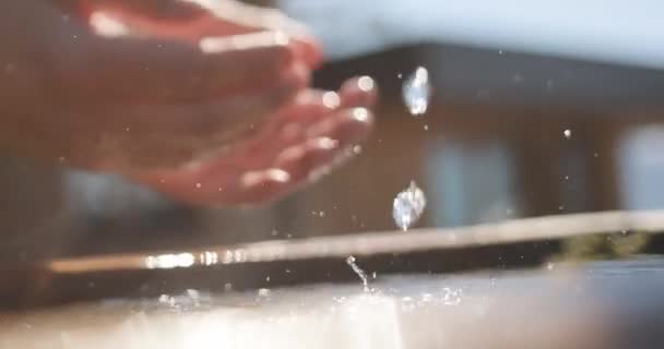 喉が渇いた男が水を汲み手から飲んでいる. — ストック動画