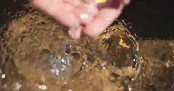 Super close-up filmato di acqua cristallina cadere in una piscina sul fondo e le mani venire a prendere un po '. — Video Stock