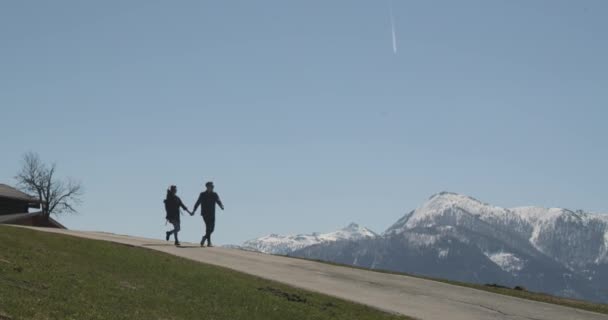 Imágenes de una pareja feliz cogida de la mano, caminando por el camino y abrazándose para un beso en un hermoso día soleado. — Vídeos de Stock