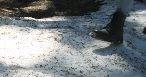 Közelkép fekete csizmáról, amin egy frissen esett havon járó személy sétál.. — Stock videók