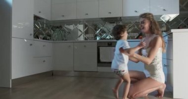 Bir annenin, oğlunu kaldırmak için diz çöktüğü ve mutfağa doğru koşarken onu öptüğü görüntüler..