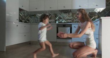 Bir annenin, oğlunu kaldırmak için diz çöktüğü ve o mutfağa koşarken ona sarıldığı görüntüler..