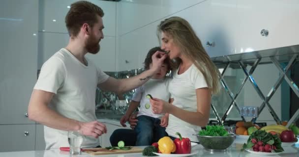 Happy family mom, dad and son cooking eating fresh vegetables together. Family bonding time. — Stock Video