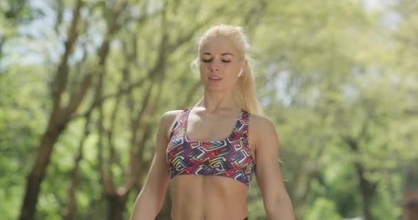 散歩の後、公園でジョギングを続ける前に彼女の時間をチェックする魅力的なブロンドのフィットネス女性のクローズアップ映像。心臓トレーニング｜ルーチン. — ストック動画