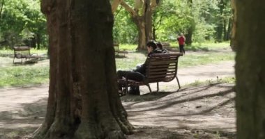 Yavaş çekimde odaklanmış, beyaz tenli, parkta koşan bir kadının tam görüntüsü. Kardiyo çalışma rutini.