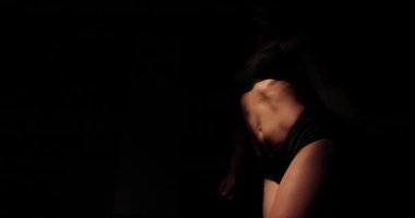 Çekici sarışın kadın siyah arka planda mükemmel tonda seksi vücuduyla hava atıyor..