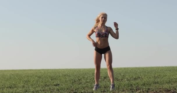 Ung vacker atletisk flicka med en vacker atletisk figur visar sina muskler. Tränare visar hans kropp efter ett hårt träningspass — Stockvideo