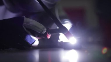 Metal kaynakçı maskesini kapat. Usta metali kaynaklıyor..