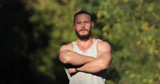 Retrato de un atractivo joven barbudo con camisa mirando a la cámara al aire libre — Vídeo de stock