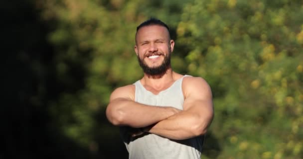 Портрет м'язистого сильного чоловіка після тренування, дивлячись на камеру, спортсмен на відкритому повітрі на заході сонця, спорт та концепція мотивації . — стокове відео
