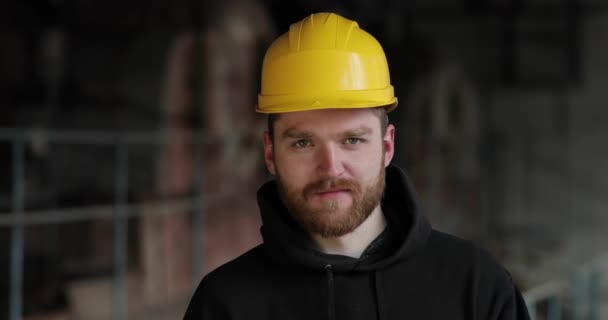 Ritratto ravvicinato di un maestro maschio con casco giallo. uomo con barba rossa — Video Stock