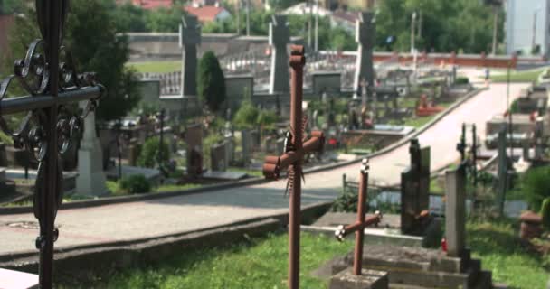 Promenade dans le cimetière entre les tombes. Beaucoup de tombes. Croix et statues dans le cimetière près de la passerelle — Video