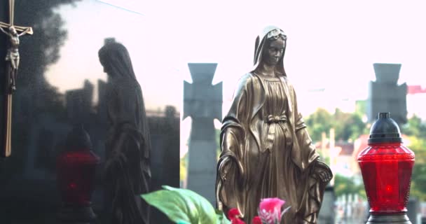 墓地にメアリーの黄金の彫刻。お墓のろうそく。人工花 — ストック動画