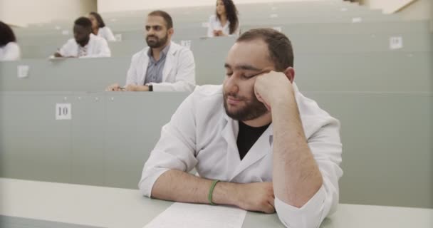 Un estudiante de medicina exhausto se queda dormido dando conferencias. — Vídeo de stock