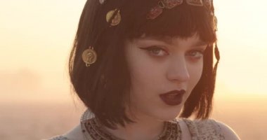 Genç bir kadının yakın yüzü. Kızlar piercing ve seksi bir görünüş. Saç kesimi. Altın mücevherli kız. Göz kalemli gözler ve koyu kahverengi rujlu dudaklar.