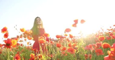 Çiçek tarlasında kendi etrafında dönen şapkalı güzel kız. Genç ve güzel bir kadın flört ediyor ve sahada eğleniyor. Portre görüntüsü. Yakın plan. 4K.