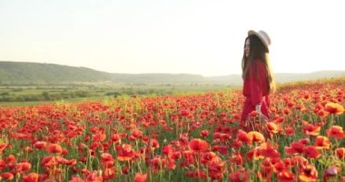 Güzel bir kadın kırmızı bir çiçek tarlasında duruyor. Çekici gülüşü olan genç ve güzel bir kadın. Dikiz aynası. 4 bin. Güzel manzara