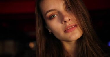 Mavi efekt. Güzel yeşil gözlü ve esmer saçlı çekici genç bayanı yakından çekerken kameraya bakıyor ve inanılmaz görünüşüyle büyülüyor. Işık odası