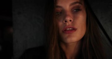 Güzel yeşil gözlü ve esmer saçlı çekici genç bayanı yakından çekerken kameraya bakıyor ve inanılmaz görünüşüyle büyülüyor. Işık odası