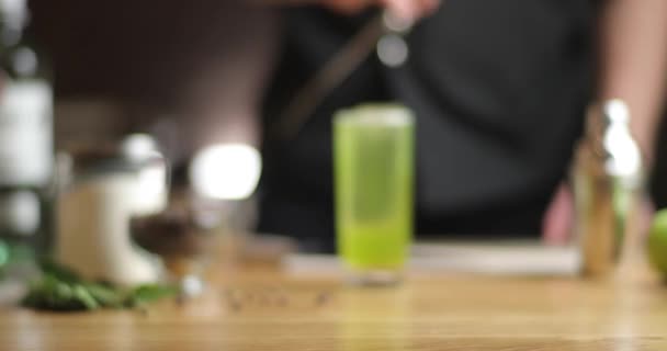 Primo piano il barista mescola il cocktail verde. cocktail verde con foglia di alloro sul tavolo. — Video Stock