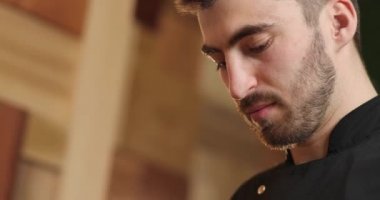 yakın plan şefler yüzlerini ve elleri elmaları kesiyor. Sakallı şef aşçı.