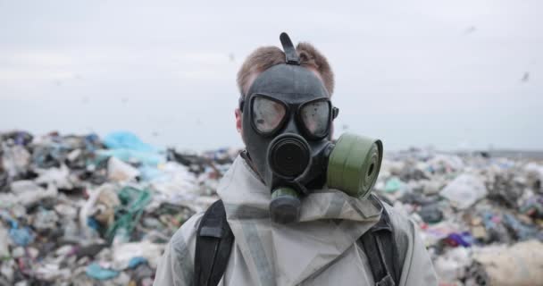 Man in protective costume and mask looking in camera. Ecological catastrophe, Apocalypse or armageddon concept. Man is wearing gas mask. — Stock Video