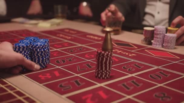 Nahaufnahme des Dealers arbeitet im Casino und bewegt Chips mit seinen Händen zum Spieler am Spieltisch — Stockvideo