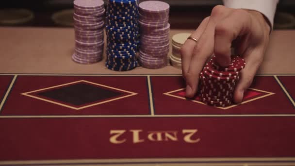 男子手的近距离射击把筹码放在赌场里的轮盘赌桌上。赌轮盘赌 — 图库视频影像