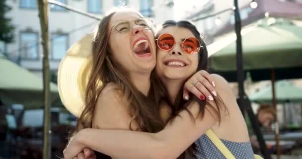 Zwei glückliche Freunde freuen sich sehr, sich zu treffen und zu umarmen. attraktive Freundinnen haben Spaß — Stockvideo