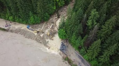 Karpatlar 'daki toprak kaymaları yüzünden yokedilmiş otoyol. Sel felaketinin sonuçları. Özel ekipmanlar yolu kayalardan ve taşlardan temizler. Özel ekipman yolu temizliyor.