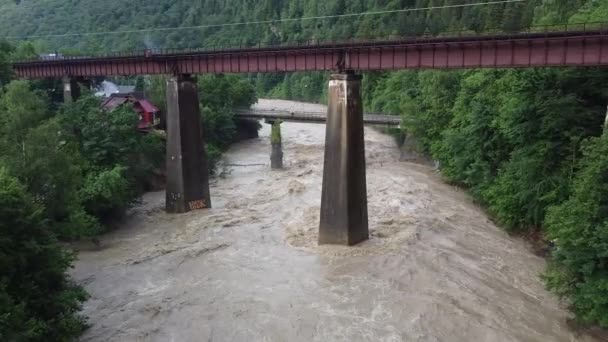 Гірська річка після сильних дощів. Два великих мости через річку. Річка піднімається з берегів. — стокове відео