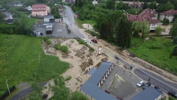 Flygfoto över lantgård påverkas av våren översvämningar med gård hus, silo på torr mark, boskap, gröna fält, brunt översvämningsvatten, täckta vägar — Stockvideo