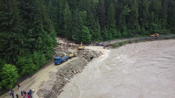 Hava görüntüsü. Özel ekipmanlar yoldaki toprak kaymalarının etkilerini temizler. Kazıcılar, dağ nehri atılımının felaketinden sonra otoyolu temizliyorlar. Ukrayna 'da zorluklar — Stok video