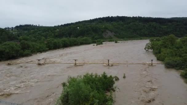 Fiume di montagna sporco con una forte corrente su uno sfondo di bellissime montagne dei Carpazi. vista aerea, tiro con droni — Video Stock