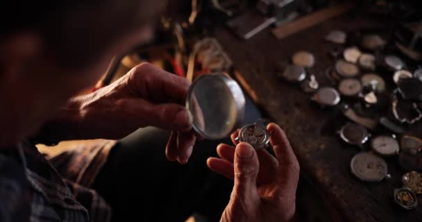 Stary zegarmistrz naprawia zabytkowy zegarek ręczny w swoim warsztacie — Wideo stockowe