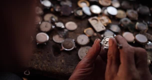 Portrait close up of a professional watchmaker repairer working on a vintage mechanism clock in a workshop — Stock Video