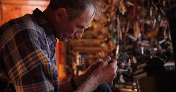 Hodinář v košili sedí v dílně a opravuje staré hodinky. retro hodinky. — Stock video