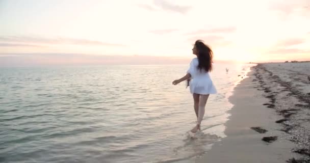 Mujer bonita con el pelo negro corre cerca del mar disfrutando de la libertad, viajar. Hermosa chica feliz fuera — Vídeo de stock