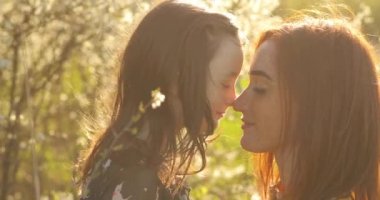 Güzel anne ve küçük kızı dışarıda. Doğa. Güzel anne ve çocuğu parkta birlikte oynuyorlar. Mutlu bir ailenin açık hava portresi. Anneler Günün kutlu olsun. Anne ve Bebek