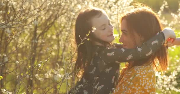 Mamá y su hija jugando y besándose, concepto de unidad. Familia cariñosa. — Vídeos de Stock