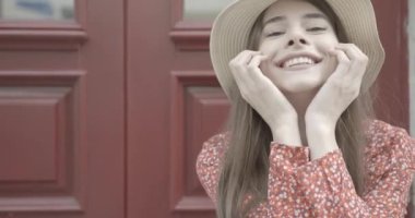 Yazlık şapkalı harika bir esmer, kameraya bakıyor ve gülümsüyor. Dış mekan. 4K görüntü. Yakın plan portre.