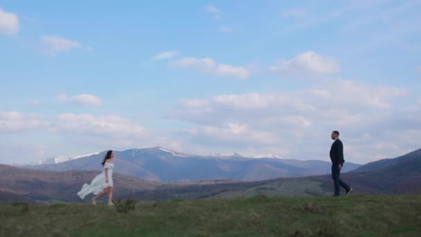Smukke kærlige par gå til at møde hinanden på en baggrund af smukke bjerge og natur. – Stock-video