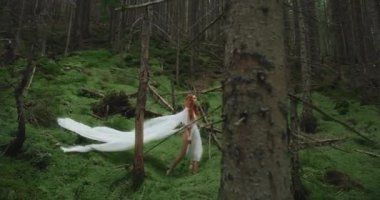 Kızıl saçlı güzel bir kız, uzun beyaz elbiseli, yeşil ağaçların arasında, sık nemli ormanlarda, dağ deresinin yakınında yürüyor. Mutlu kadın dışarıda eğleniyor..